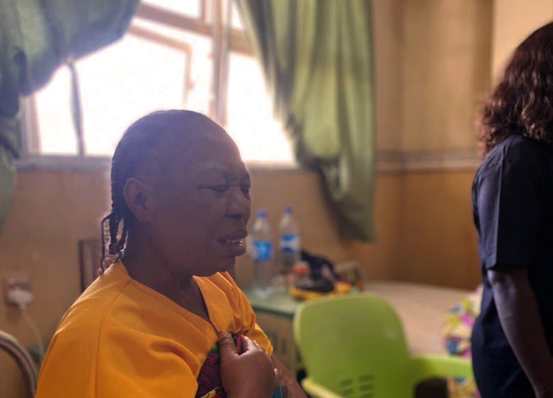 A member praying with a woman during a hospital visit