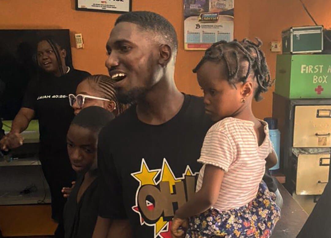 A member carrying a child during an orphanage visit