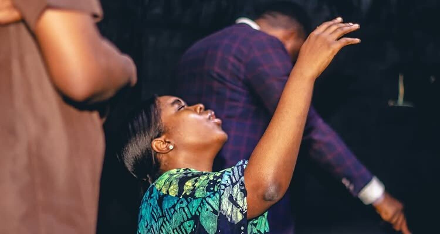 Worshippers with hands raised during the Mid-Year Thanksgiving Service